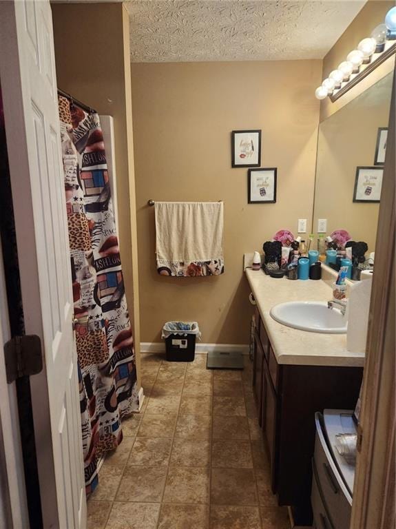 bathroom with tile floors, a textured ceiling, and vanity