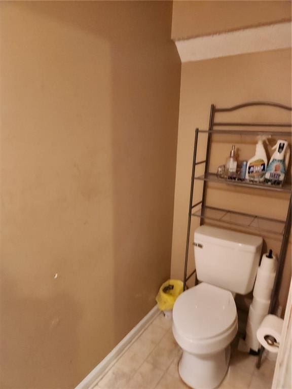 bathroom featuring tile flooring and toilet