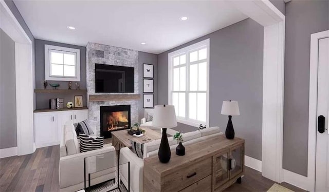 living room featuring a large fireplace, dark hardwood / wood-style floors, and a wealth of natural light