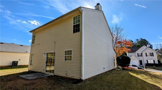 rear view of property with a yard and central AC