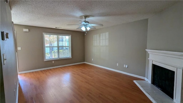 unfurnished living room with ceiling fan, a textured ceiling, and hardwood / wood-style flooring