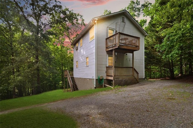 view of front of property with a balcony and a yard