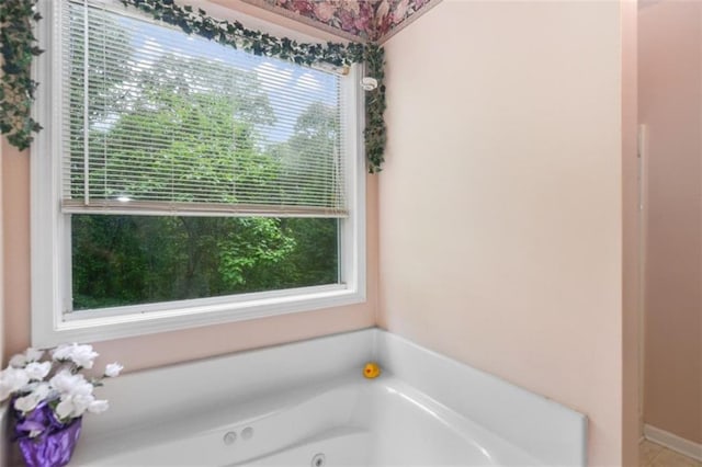 bathroom featuring a wealth of natural light and a tub to relax in