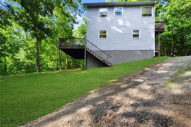 rear view of house featuring a wooden deck and a lawn