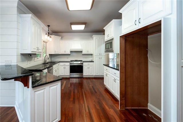 kitchen with sink, appliances with stainless steel finishes, white cabinetry, hanging light fixtures, and kitchen peninsula