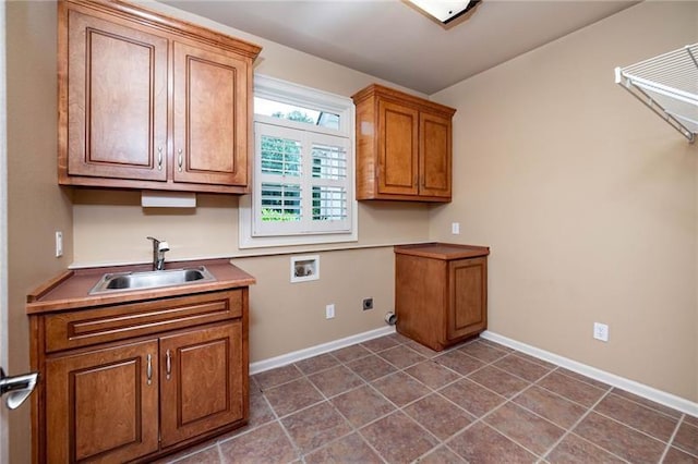 clothes washing area featuring sink, electric dryer hookup, hookup for a washing machine, cabinets, and dark tile patterned flooring