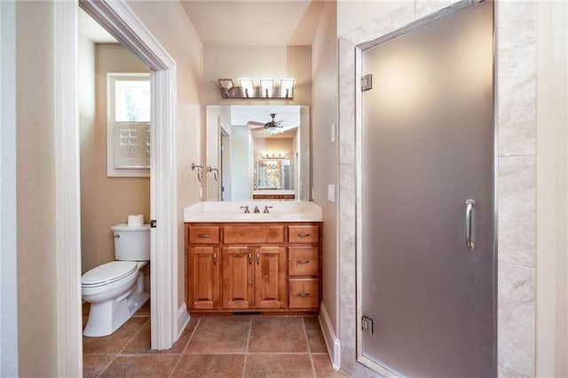 bathroom featuring walk in shower, vanity, toilet, and tile patterned flooring