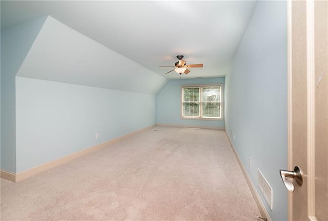 bonus room with vaulted ceiling, light carpet, and ceiling fan