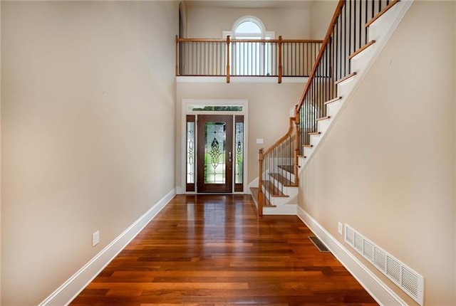 foyer entrance with a high ceiling and dark hardwood / wood-style floors