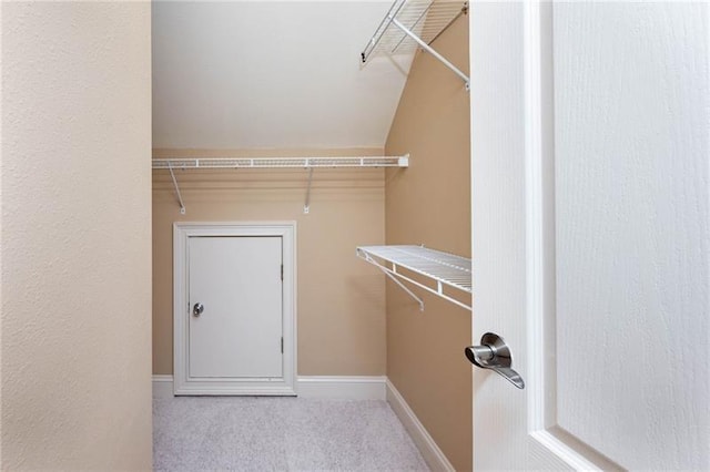 walk in closet featuring light colored carpet