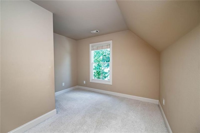 additional living space with vaulted ceiling and light carpet