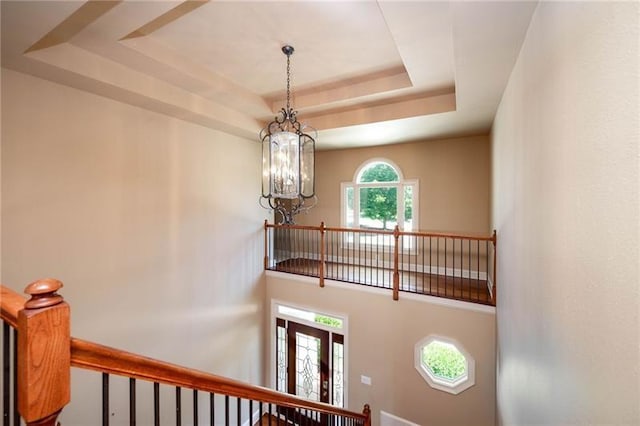 interior details with a raised ceiling and a chandelier