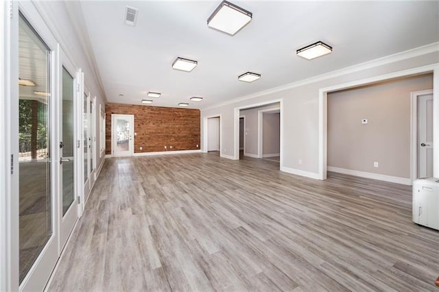 unfurnished living room featuring crown molding, french doors, and light wood-type flooring