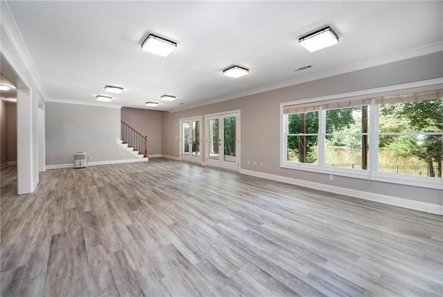 unfurnished living room featuring ornamental molding and light hardwood / wood-style flooring