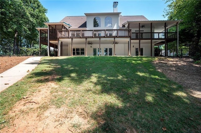 rear view of house with a yard and ceiling fan