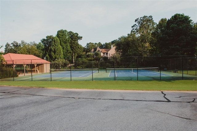 view of tennis court featuring a lawn