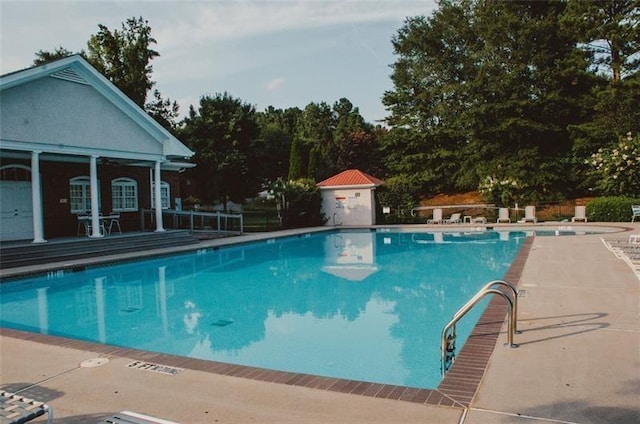 view of pool featuring an outbuilding and a patio