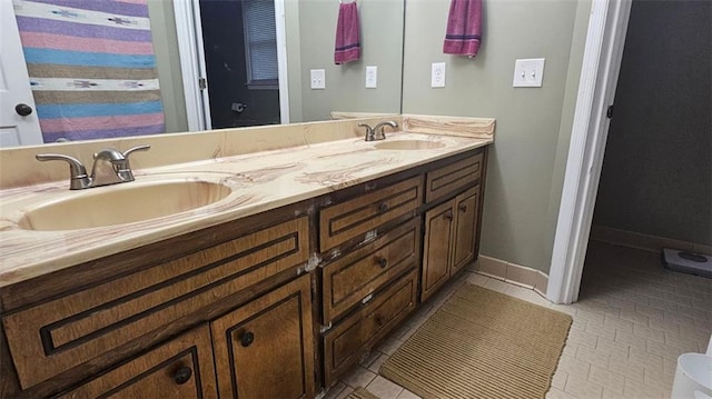full bath featuring double vanity, tile patterned floors, and baseboards