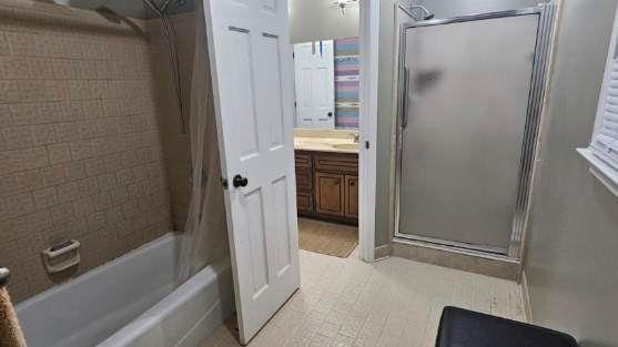 bathroom with vanity and enclosed tub / shower combo