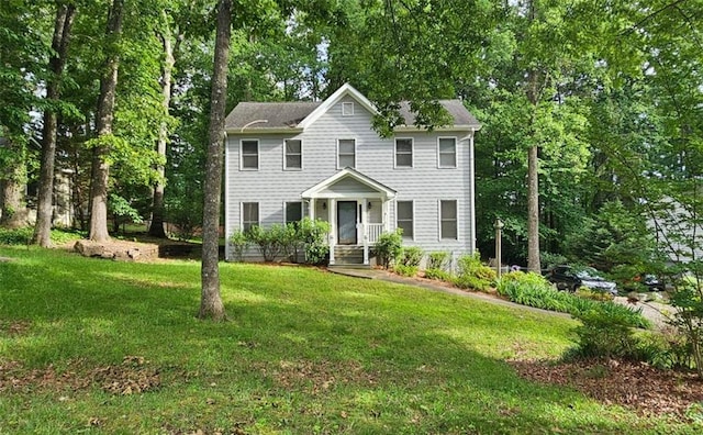 colonial-style house with a front yard and view of scattered trees
