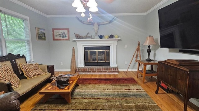 living area featuring wood finished floors, crown molding, a fireplace, and baseboards
