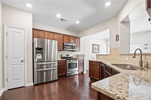 1655 Hampton Oaks Dr, Alpharetta, GA 30004 - kitchen with stainless steel appliances, a peninsula, light stone countertops, dark wood finished floors, and decorative backsplash