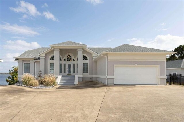 view of front of home featuring fence, an attached garage, driveway, and stucco siding