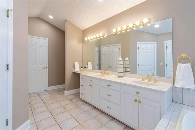 full bathroom featuring double vanity, vaulted ceiling, a sink, and tile patterned flooring