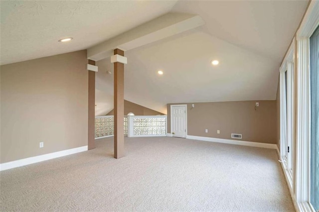 additional living space with baseboards, vaulted ceiling, carpet flooring, and visible vents