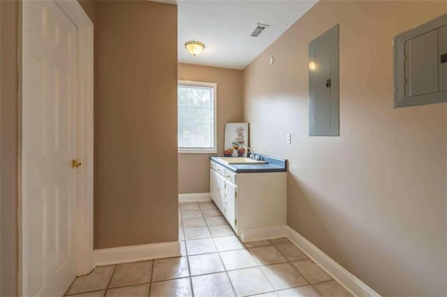 interior space featuring baseboards, visible vents, light tile patterned floors, and electric panel