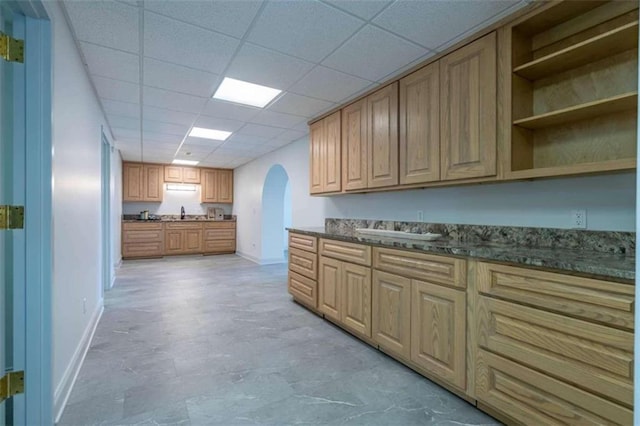laundry area featuring baseboards and arched walkways