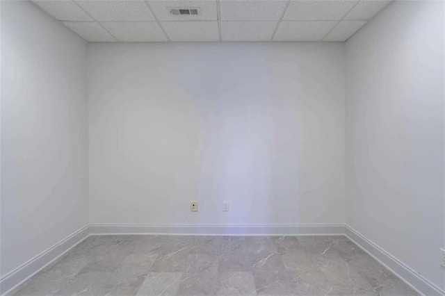 unfurnished room with visible vents, baseboards, and a drop ceiling
