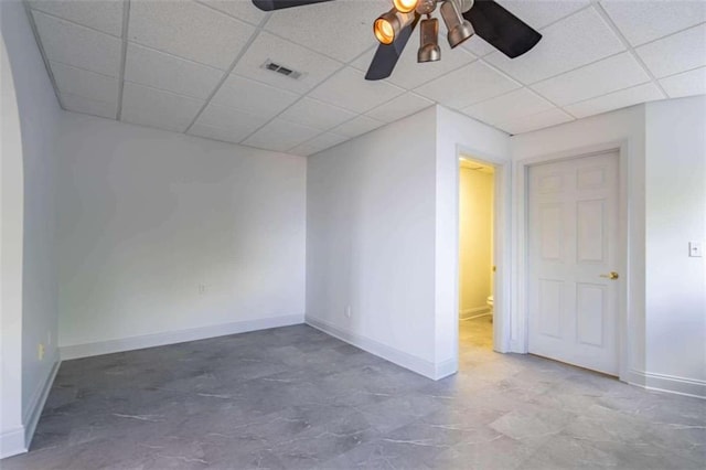 empty room with a ceiling fan, baseboards, visible vents, and a paneled ceiling