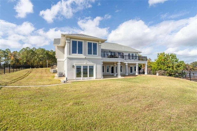 back of house with a yard, fence, french doors, and stucco siding