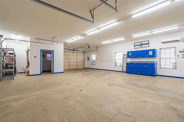 garage with a wall mounted air conditioner and a garage door opener
