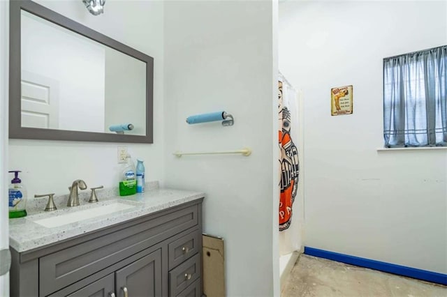 full bath featuring vanity, baseboards, concrete flooring, and curtained shower