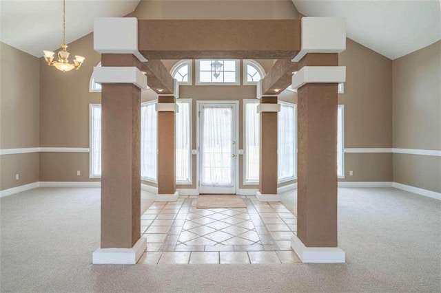 foyer entrance with carpet floors, baseboards, ornate columns, and a notable chandelier