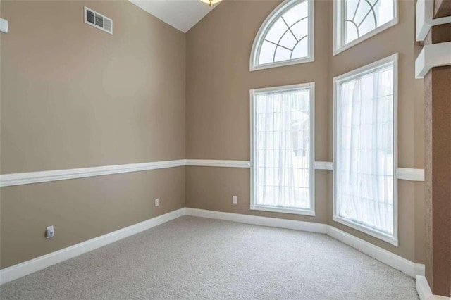 unfurnished room featuring baseboards, carpet flooring, and visible vents