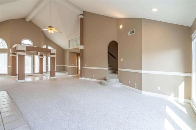 unfurnished living room featuring a ceiling fan, visible vents, high vaulted ceiling, baseboards, and carpet