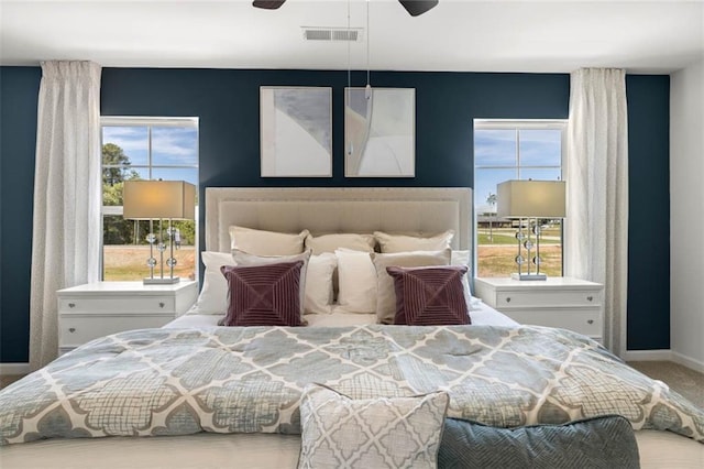 bedroom with ceiling fan and light carpet