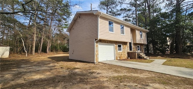 view of home's exterior with stone siding and concrete driveway