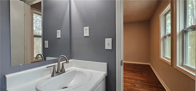 bathroom featuring wood finished floors, vanity, and baseboards