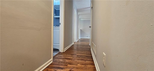 hall with dark wood finished floors and baseboards