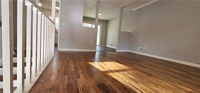 unfurnished living room featuring dark wood finished floors, visible vents, and baseboards