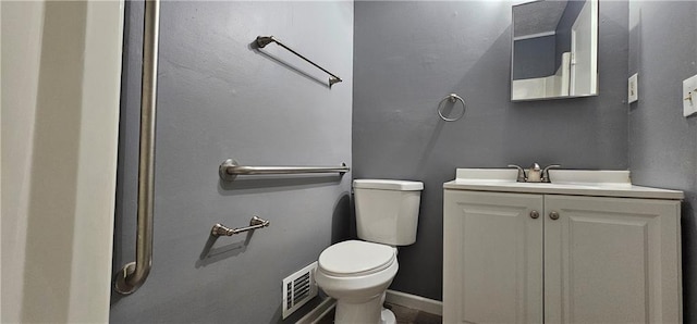 bathroom featuring baseboards, visible vents, vanity, and toilet