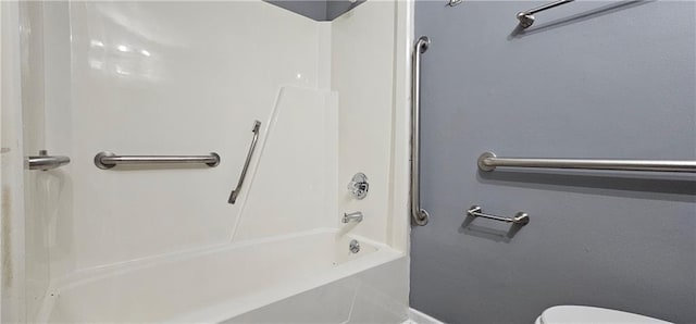 bathroom featuring tub / shower combination, toilet, and baseboards