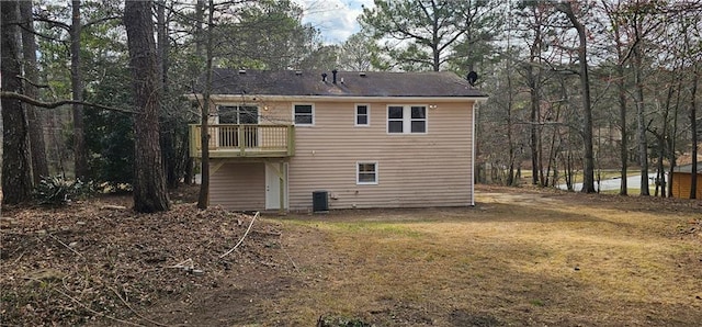 rear view of property with central AC and a lawn