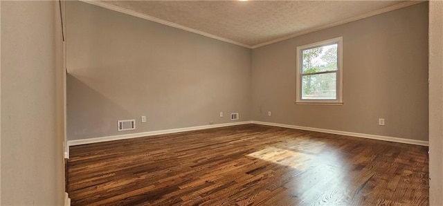 spare room with dark wood-style floors, ornamental molding, visible vents, and baseboards