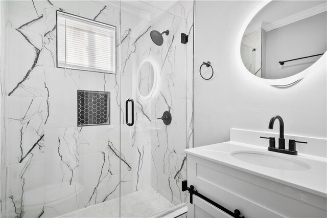 bathroom featuring a shower with door, vanity, and ornamental molding