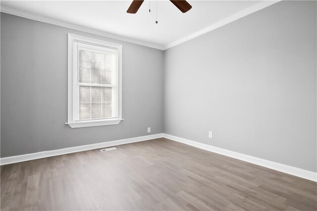 spare room featuring hardwood / wood-style floors, ceiling fan, and crown molding